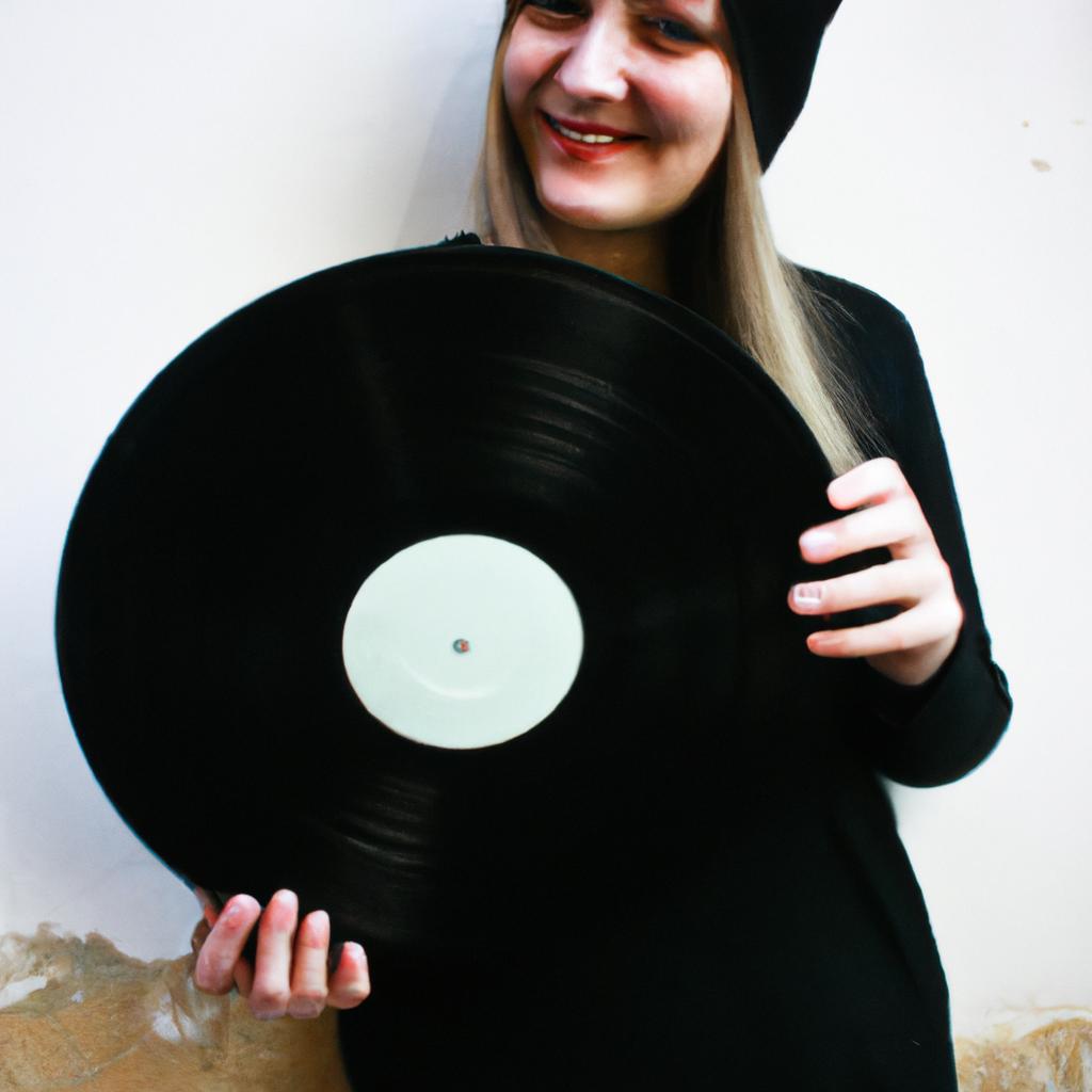 Person holding vinyl record, smiling