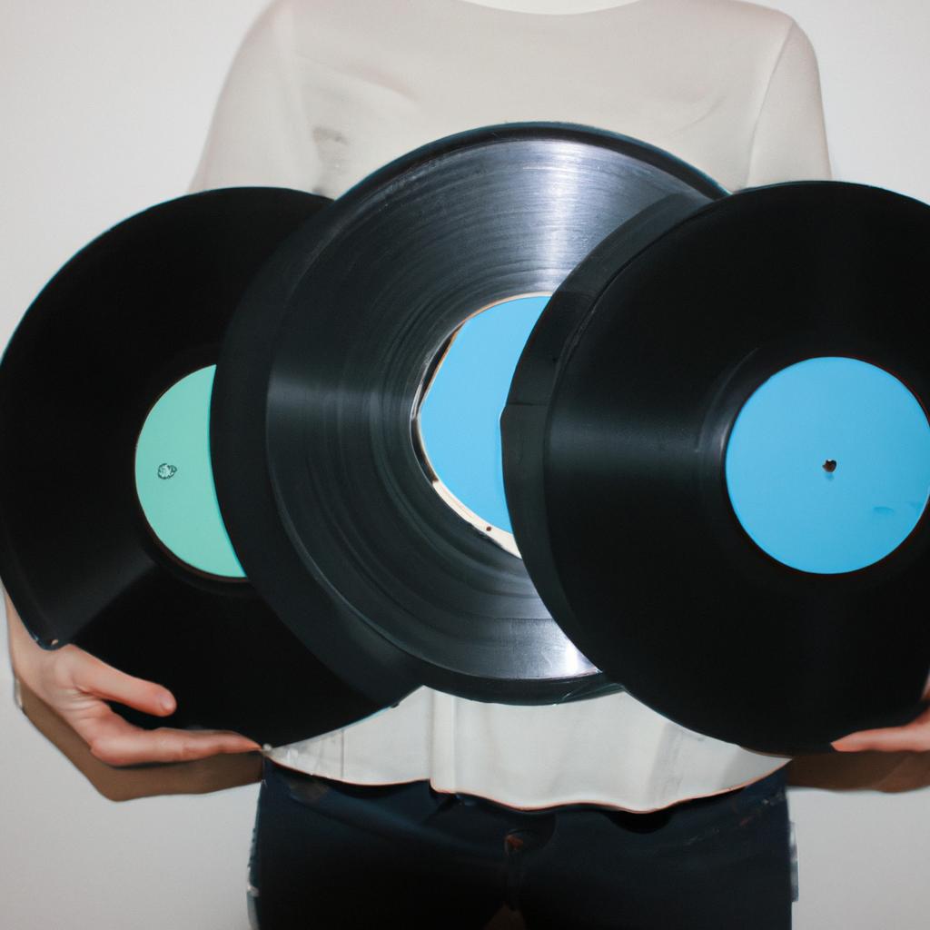 Person holding different sized records