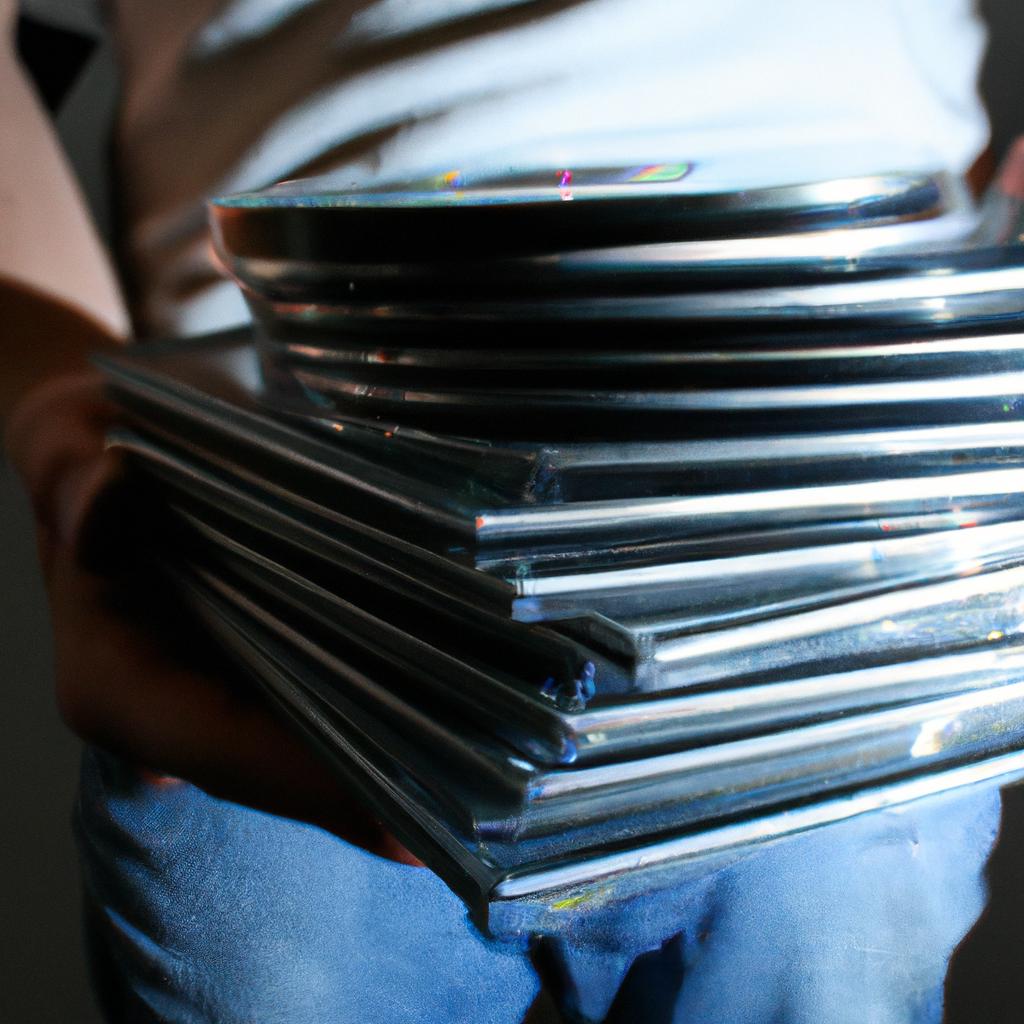 Person holding stack of CDs